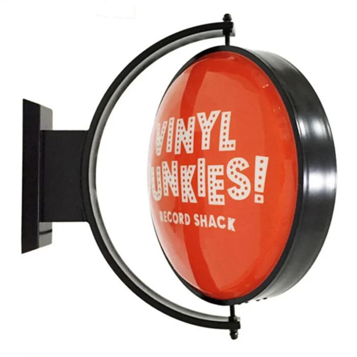 Round double-sided rotating lightbox wall sign on a wall bracket